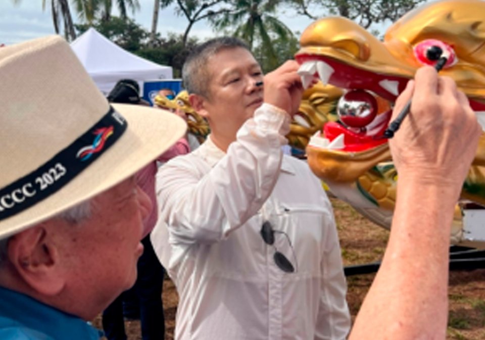 El ministro consejero de la embajada de China en Panamá, S.S. LiWuji, participando del ritual de rigor de "despertar al dragón", pintando de rojo sus ojos.