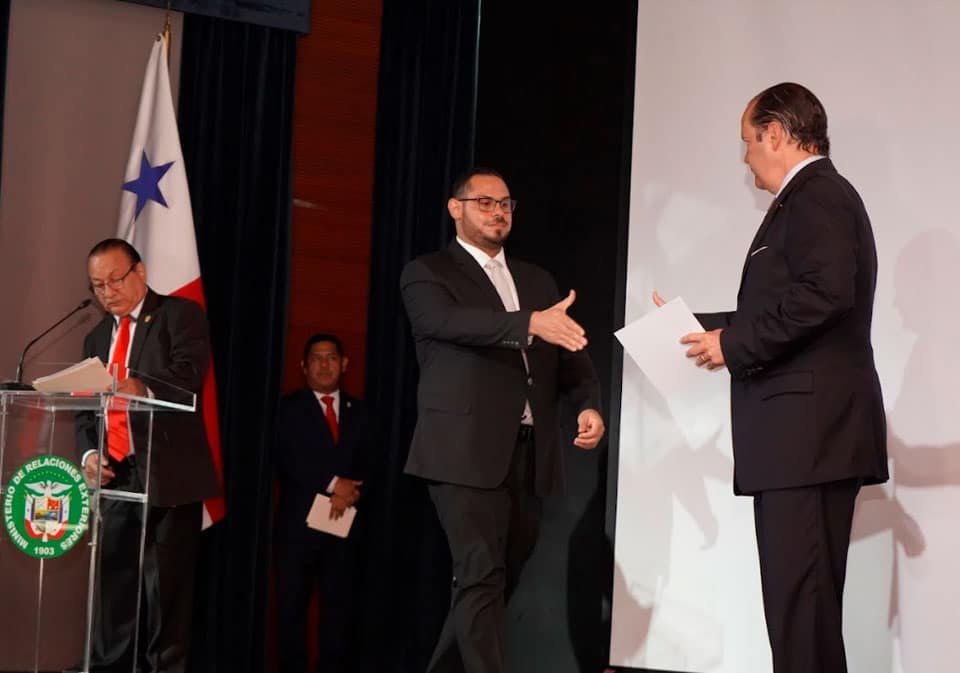 Eliezer Vásquez, maestro de ceremonias; Simón Paolo Jean Francois Pérez, primer puesto de la promoción 2025 de la Carrera Diplomática y Consular de Panamá; S.E. Javier Martínez-Acha, canciller de la República, durante la entrega del diploma.